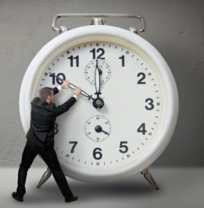 Businessman pulling a clock hand backwards